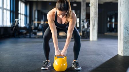 A woman doing a kettlebell workout at the gym