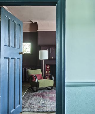 Blue entrance hall looking into purple living room