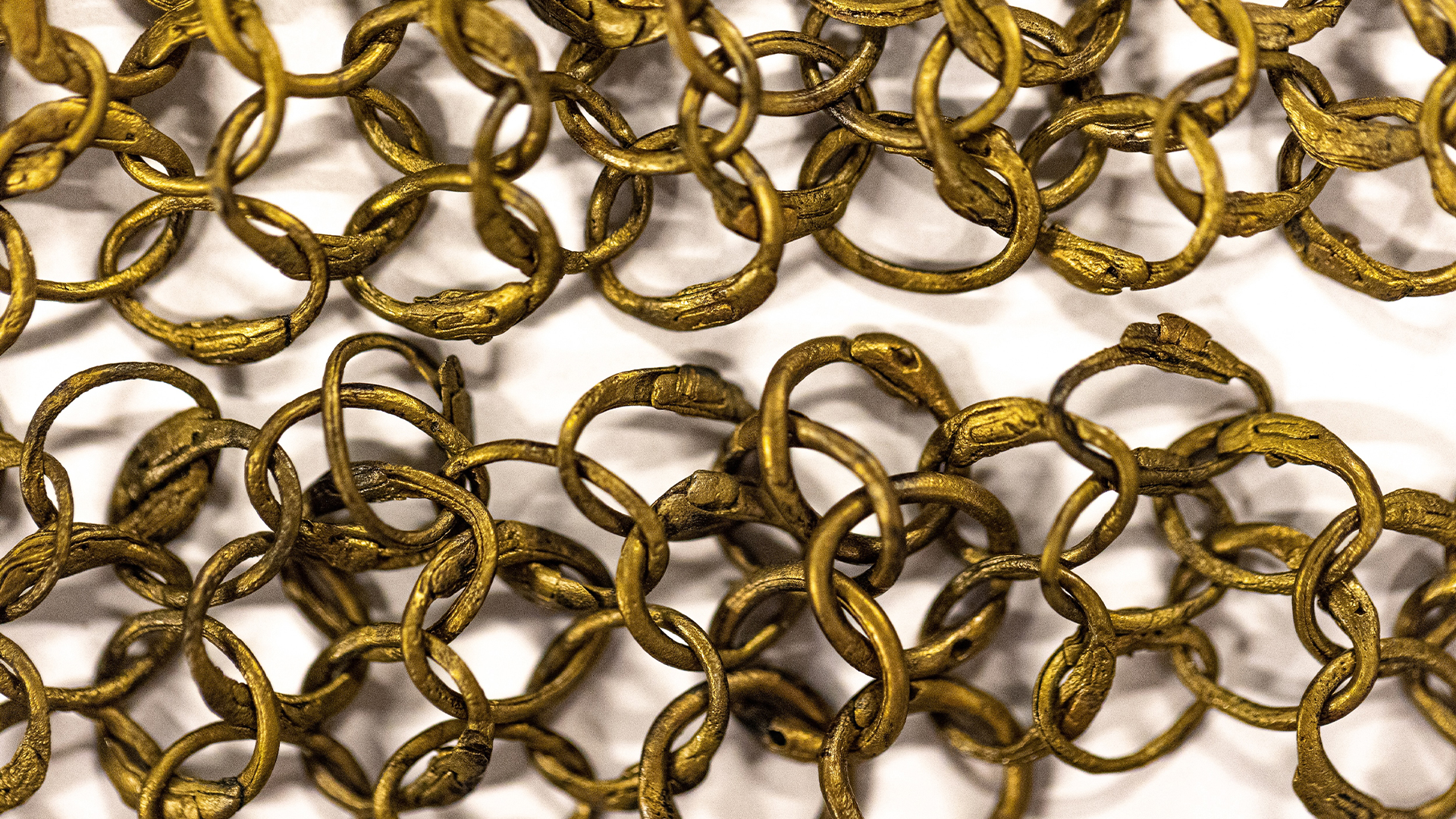Gold-colored chainmail against a white background.