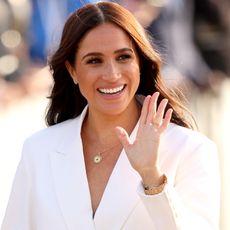 Meghan Markle in a white suit waving