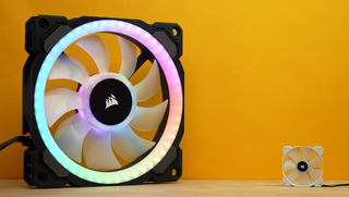 Massive 500mm cooling fan next to a smaller cooling fan a tenth of its size in front of a yellow background