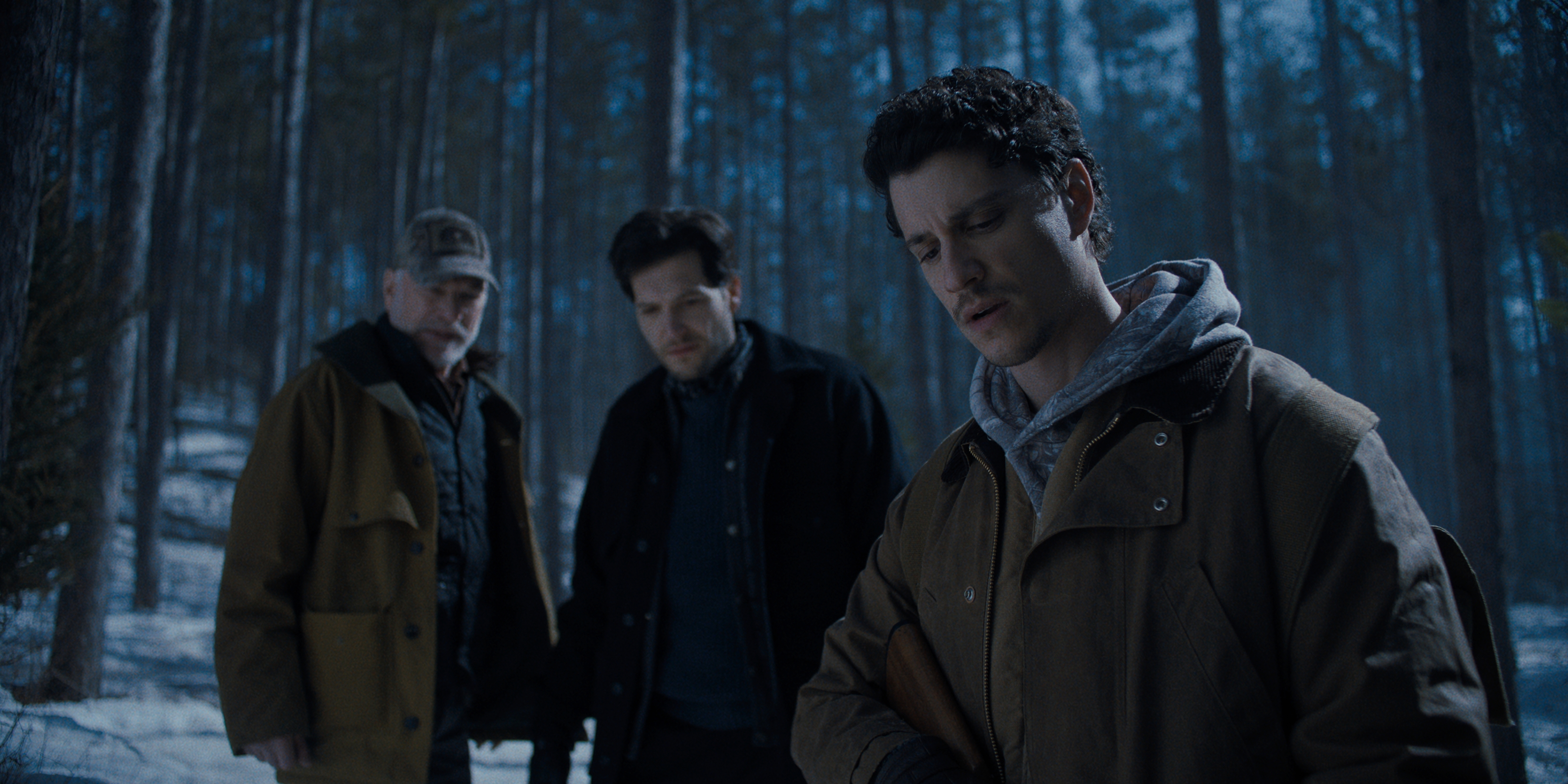 Ted Levine as Boris, Jeff Wilbusch as Jules, Adam DiMarco as Nicky Cunningham in episode 106 of Something Very Bad Is Going To Happen as they wear coats and walk through a snowy wood