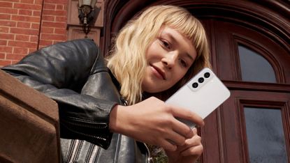 Samsung Galaxy S22 Plus Android phone being held by a woman in a black leather jacket