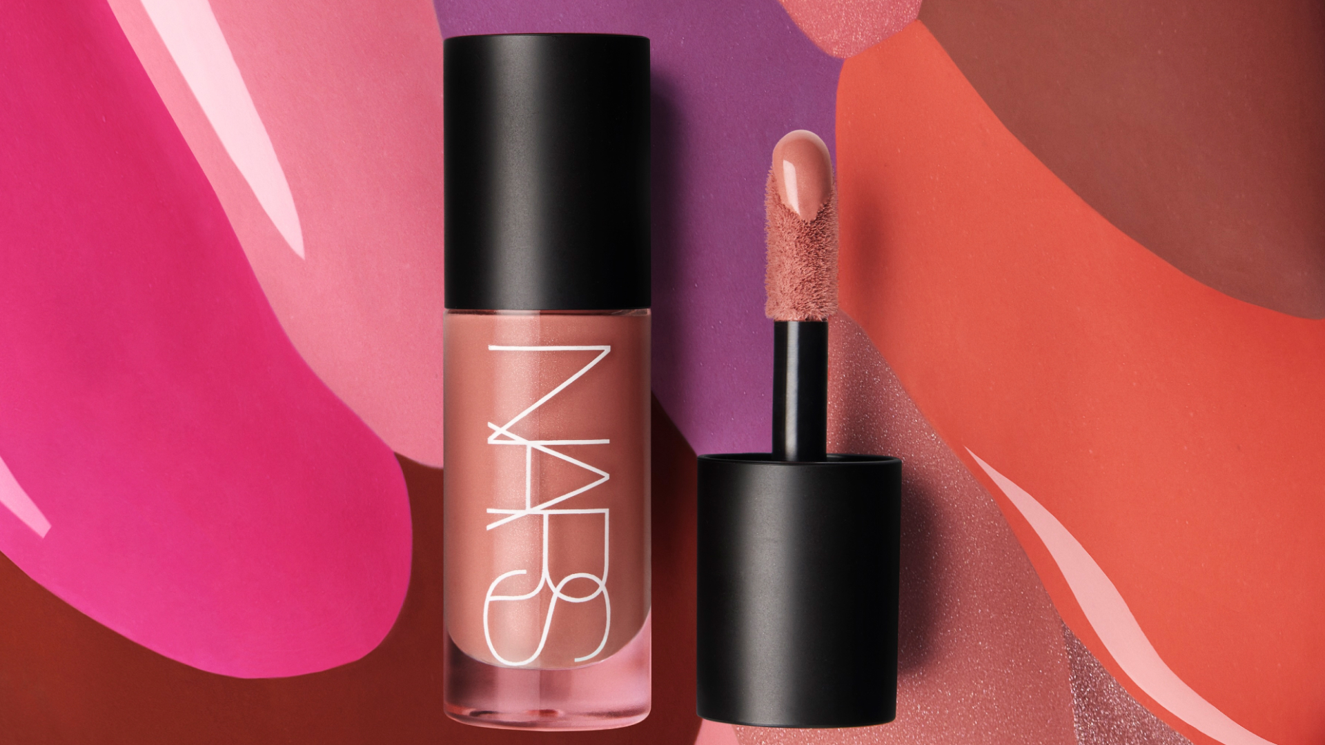A glass, tube shaped bottle with the word NARS written in white letters. It also has a black top, and there is a black top with a doe foot applicator next to it/