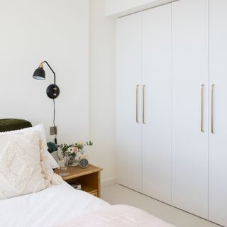 White built in closet doors, bedside table, double bed