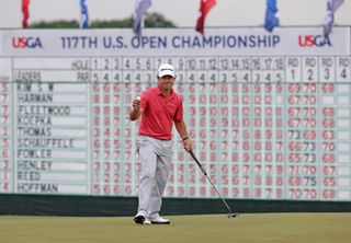 Brian Harman with his putter in front of a 2017 US Open leaderboard