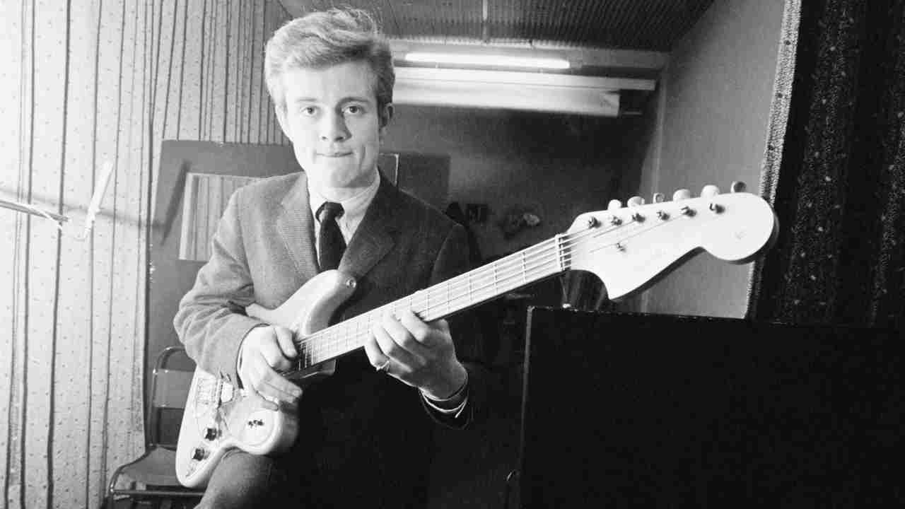 John Paul Jones posing for a photograph with a bass guitar in 1965