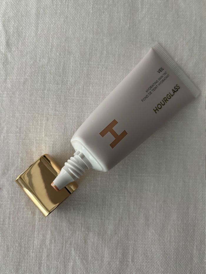 The Hourglass Veil Hydrating Skin Tint on a white linen background