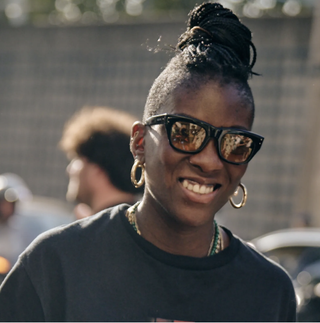 Nikki Ogunnaike wearing a T-shirt, sunglasses, and gold jewelry 