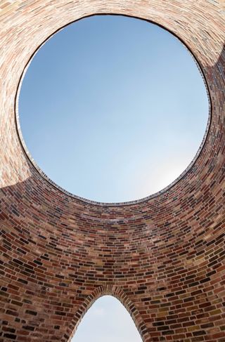 Fjordenhus, by Olafur Eliasson and Studio Olafur Eliasson in Vejle, Denmark. Round opening in a face brick roof.