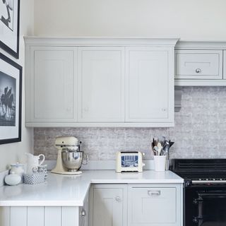 Corner of white pale grey kitchen colour scheme, worktops, and cabinets