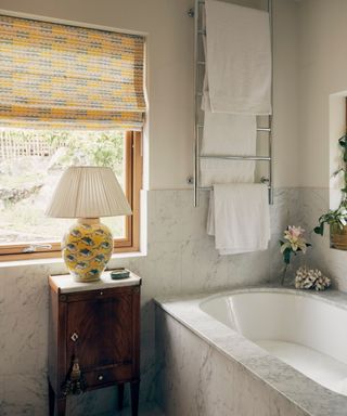 marble neutral bathroom with an unexpected yellow lamp