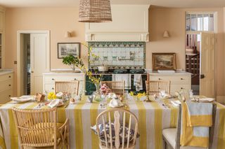 French kitchen with yellow and white stripe tablecloth and green range cooker