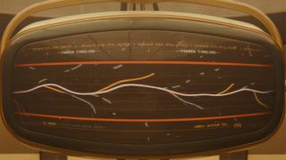 Image from the Marvel T.V. show Loki, season 2 episode 2. A retro monitor screen showing a wiggly white line with several orange lines branching off from it to show all the fractured timelines coming off from the original one.