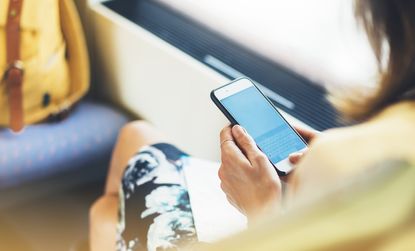 Someone looking over a woman's shoulder at a phone screen