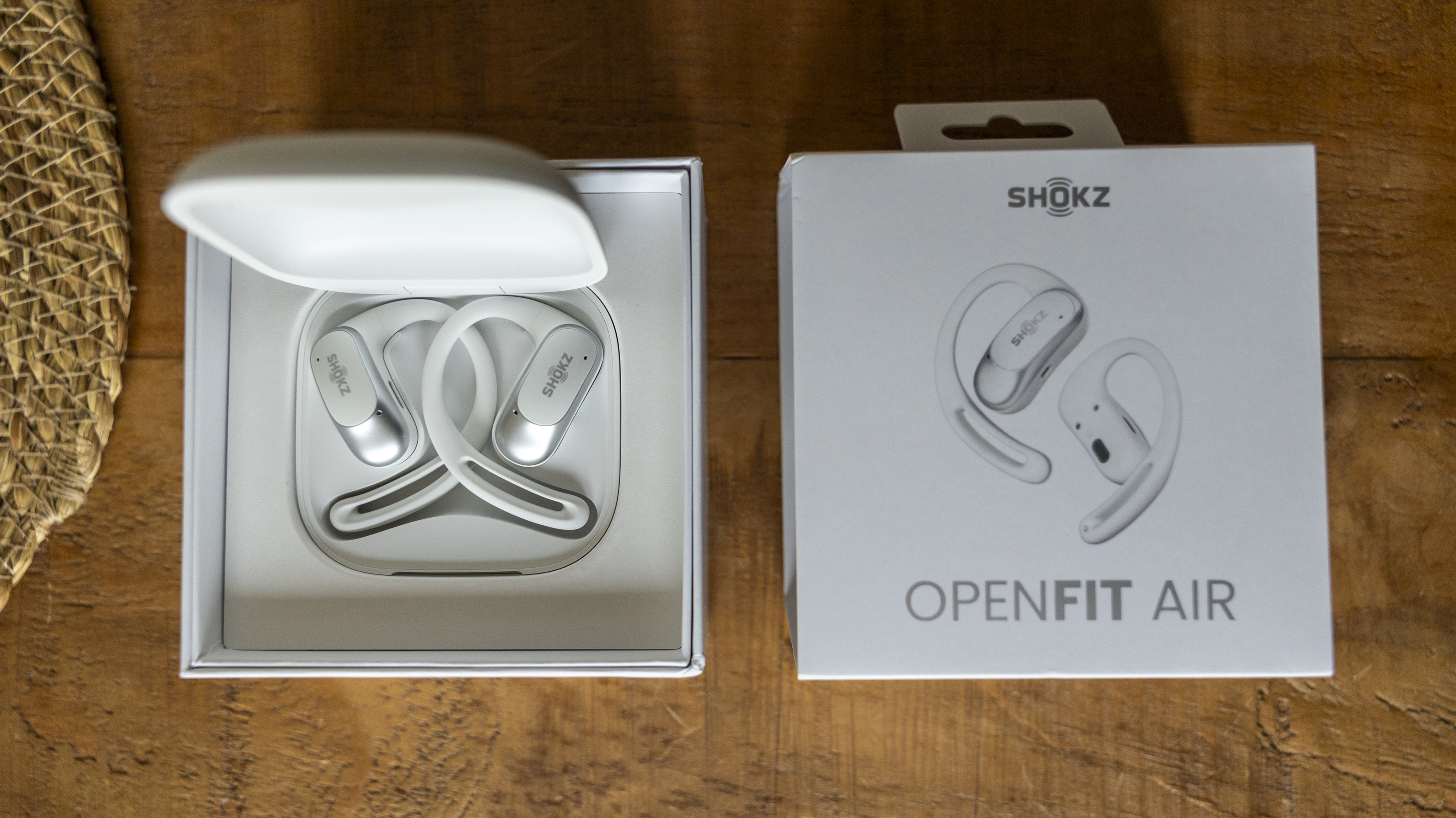 The Shokz OpenFit Air headphone box open on a wooden table