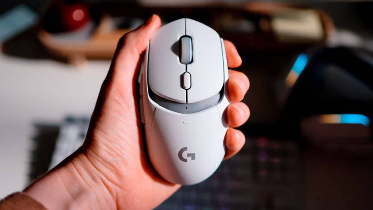 Man holding white Logitech G309 wireless gaming mouse