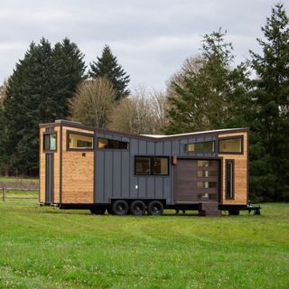 house on wheels grey exterior and grass land