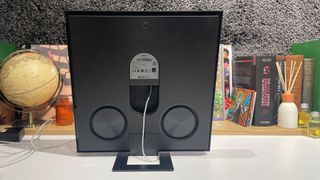 Samsung Music Frame wireless speaker on busy shelf showing back of frame