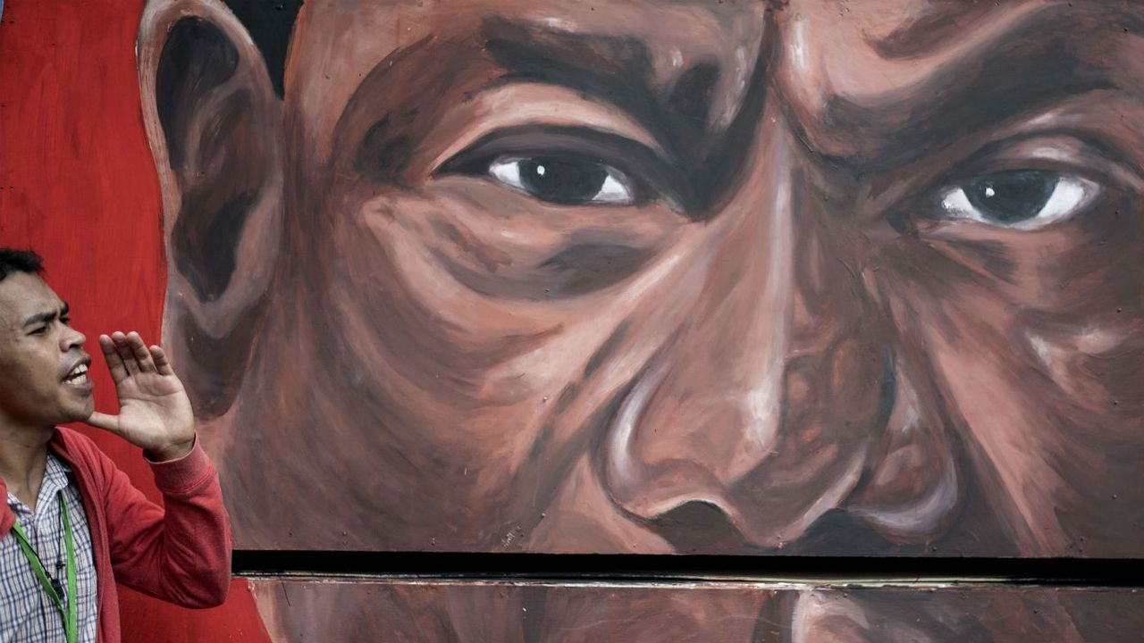 A mural of Rodrigo Duterte watches over a demonstration against drug war killings