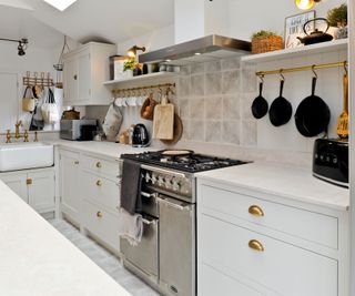 classic white kitchen with brass cup handles and stainless steel range cooker