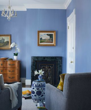 Blue room, fireplace, grey armchairs