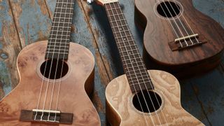 Three ukuleles lying on a wooden floor
