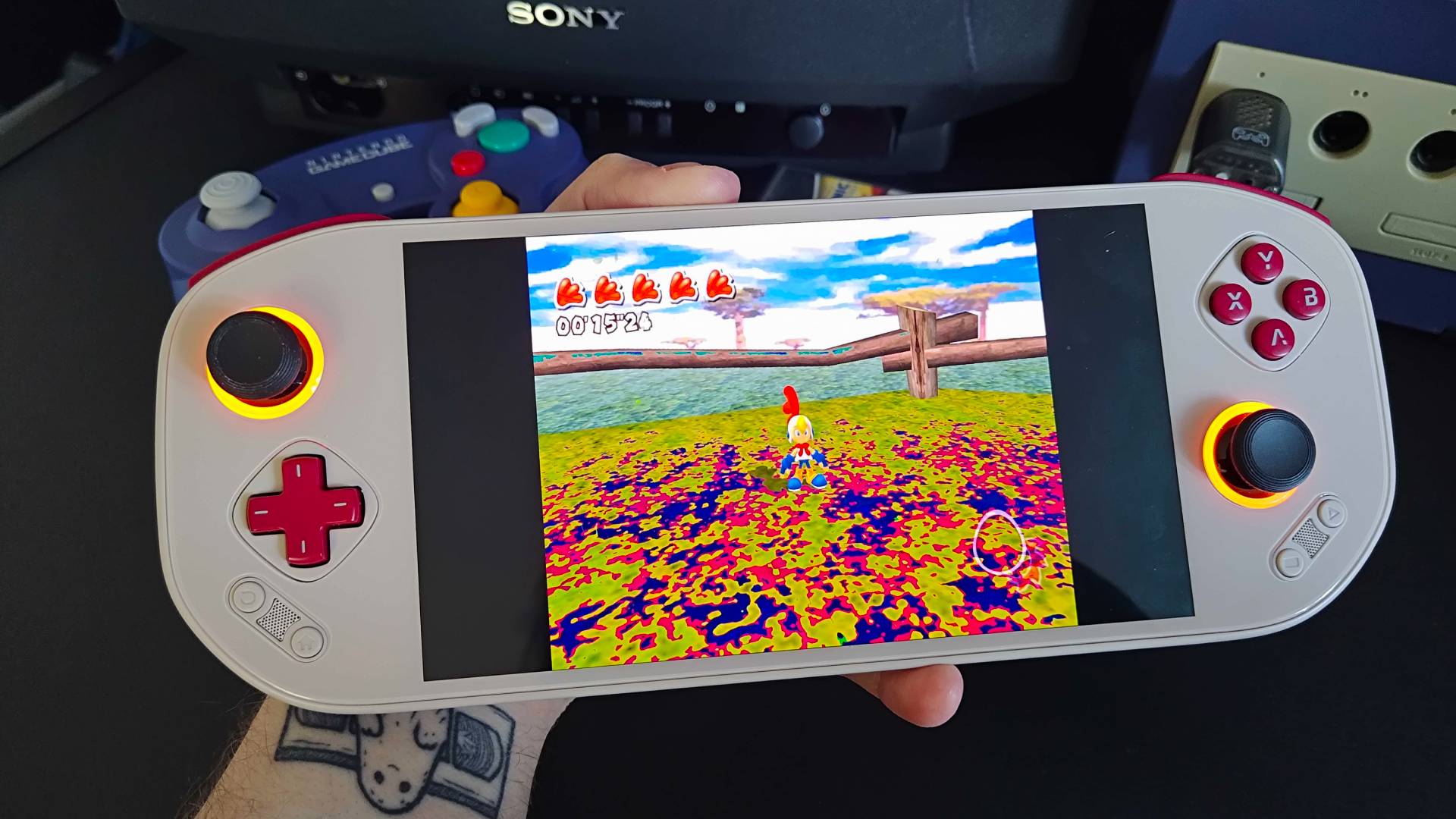 Hand holding Mangmi Pocket Max handheld with Billy Hatcher and the Giant Egg gameplay on screen.