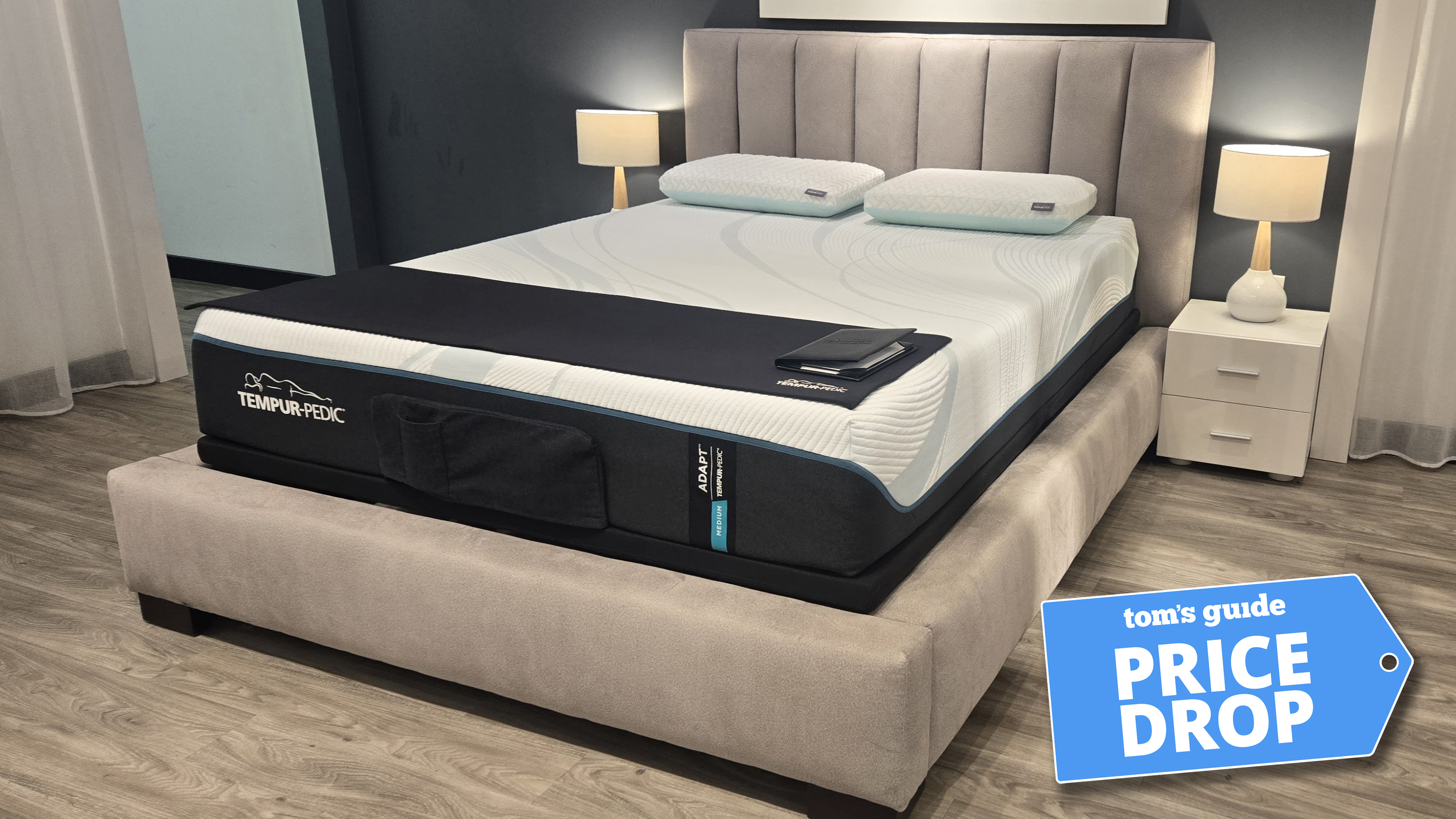 The Tempur-Pedic Tempur-Adapt Mattress in a show room, a Tom's Guide price drop deal's badge in the bottom right corner