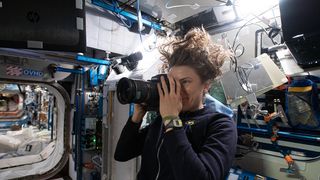  NASA astronaut and Expedition 66 flight engineer Kayla Barron takes a photograph for the SQUARE archaeology project aboard the International Space Station.
