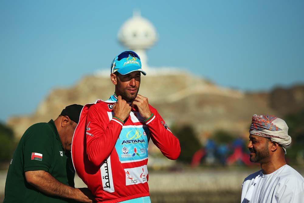 Vincenzo Nibali (Astana) pulls on the winner's red jersey on the final podium