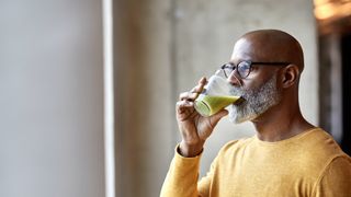 Middle-aged man drinking a smoothie and eating healthy