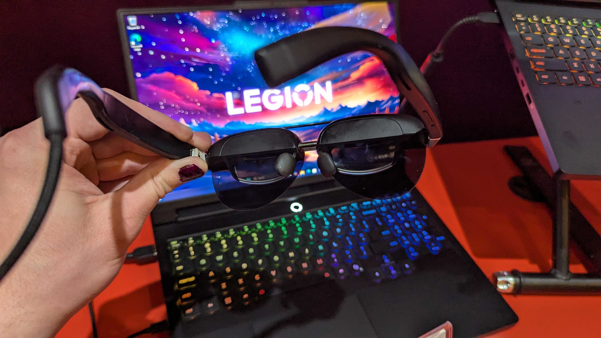 A hand holding a pair of Lenovo Legion Glasses 2