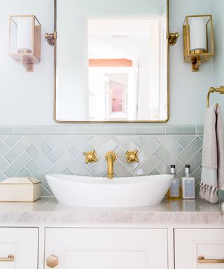 Bathroom basin with sage splashback tiles and brass mixer tap