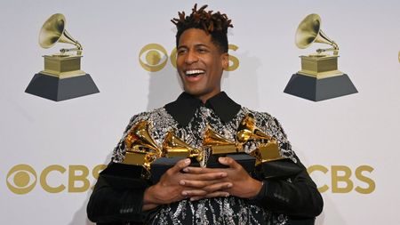 Jon Batiste holds his Grammy awards on Sunday night.