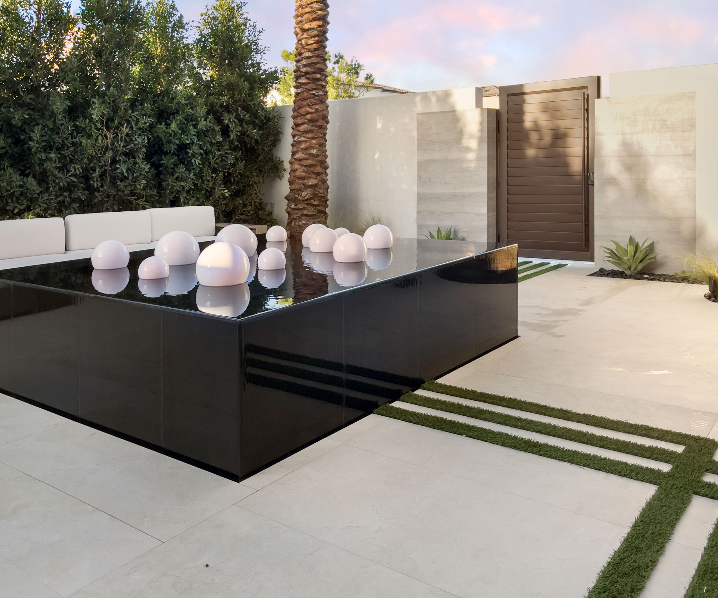 desert backyard with water feature, patio, palm tree and gate