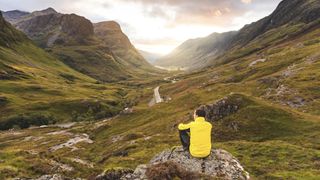 Man looking at view with the Three Sisters of Glencoe mountains, Scotland