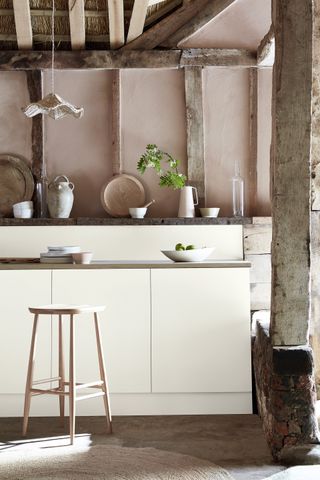 walls painted in a pink distemper with white gloss kitchen cabinetry