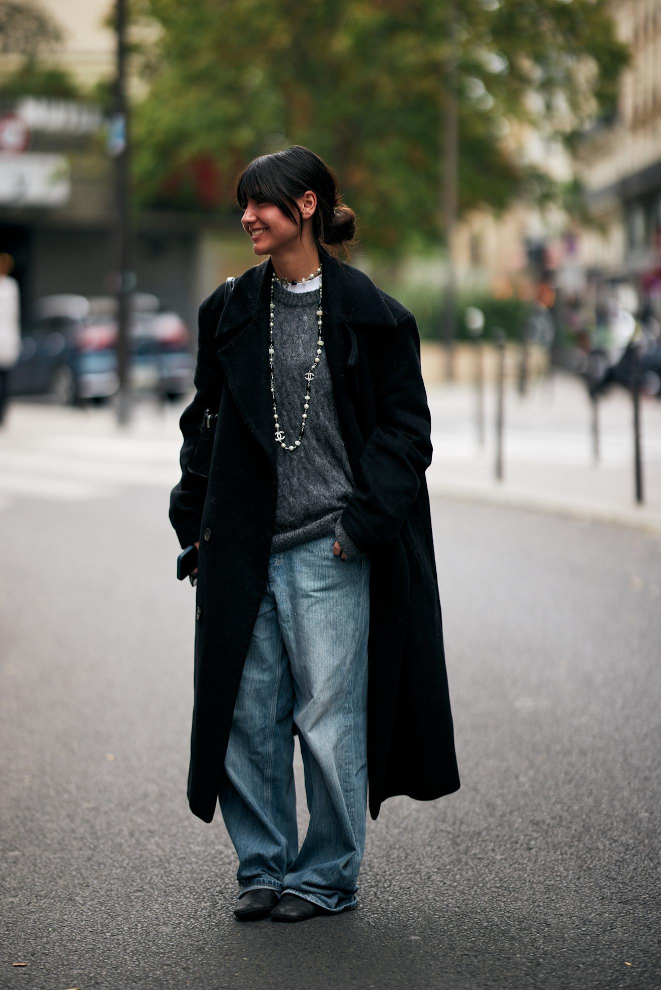 woman wearing coat, sweater, t-shirt, baggy jeans, and boots