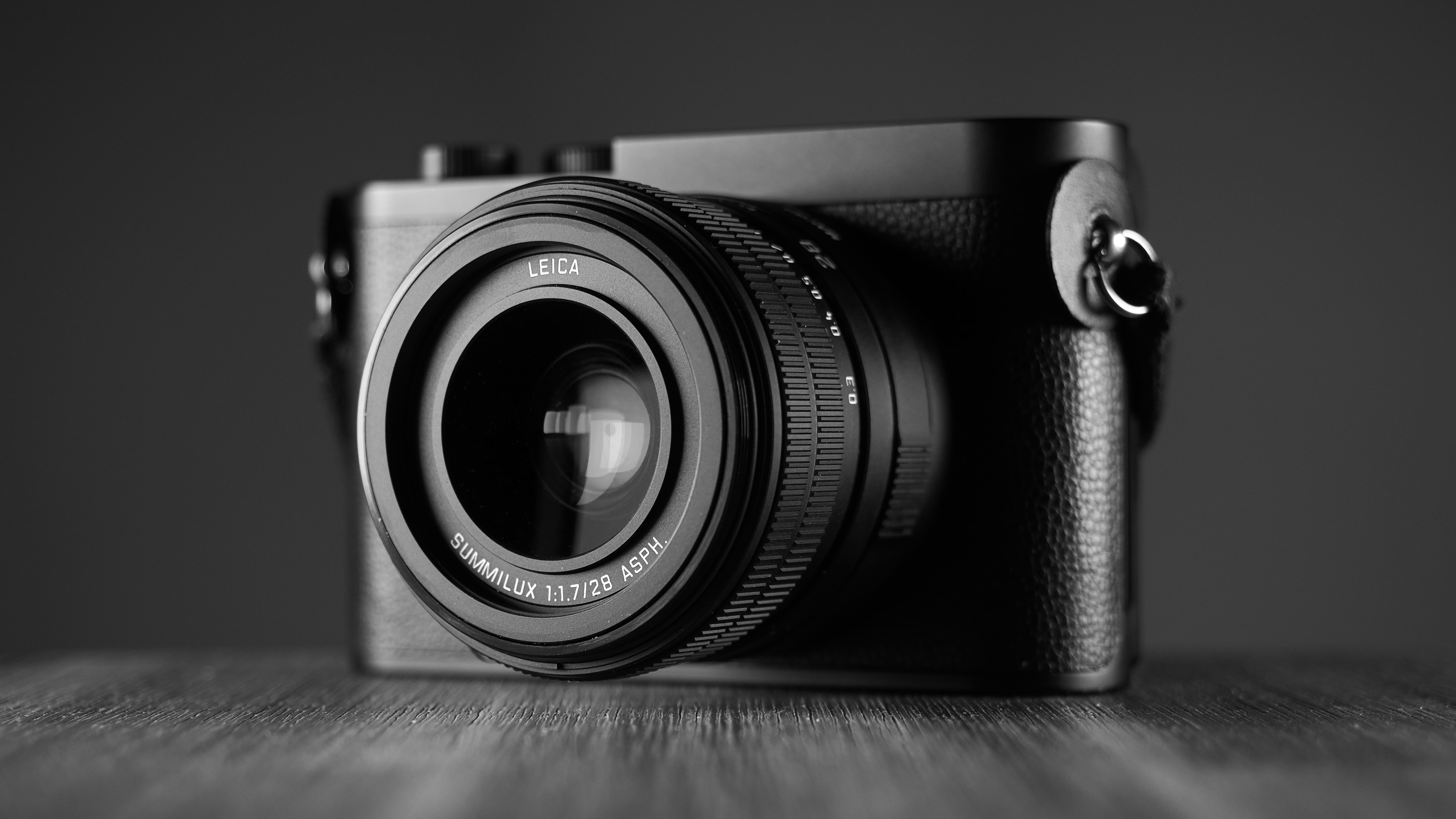 Black-and-white image of the Leica Q3 Monochrom on a wooden surface