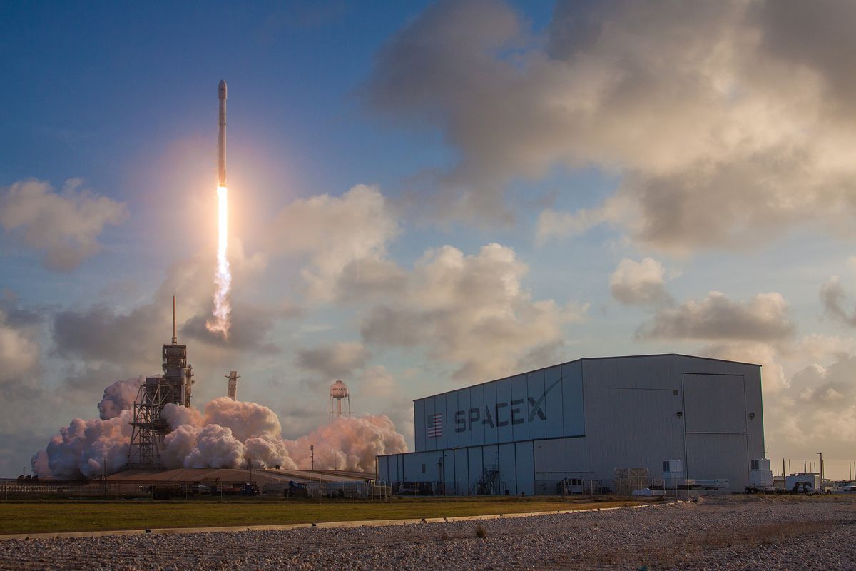 This view of the NROL-76 spy satellite shows SpaceX's horizontal integration facility (foreground) as the Falcon 9 launches into space from Pad 39-A at NASA's Kennedy Space Flight Center on May 1, 2017.