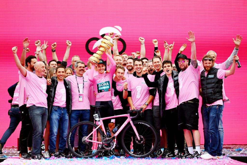 VERONA ITALY MAY 29 Ralph Denk Team manager Wilco Kelderman of Netherlands Giovanni Aleotti of Italy Cesare Benedetti of Poland Emanuel Buchmann of Germany Patrick Gamper of Austria Lennard Kmna of Germany Ben Zwiehoff of Germany and other Team Bora Hansgrohe staff members celebrate at podium the overall victory and Pink Leader Jersey of Jai Hindley of Australia and Team Bora Hansgrohe during the 105th Giro dItalia 2022 Stage 21 a 174km individual time trial stage from Verona to Verona ITT Giro WorldTour on May 29 2022 in Verona Italy Photo by Tim de WaeleGetty Images