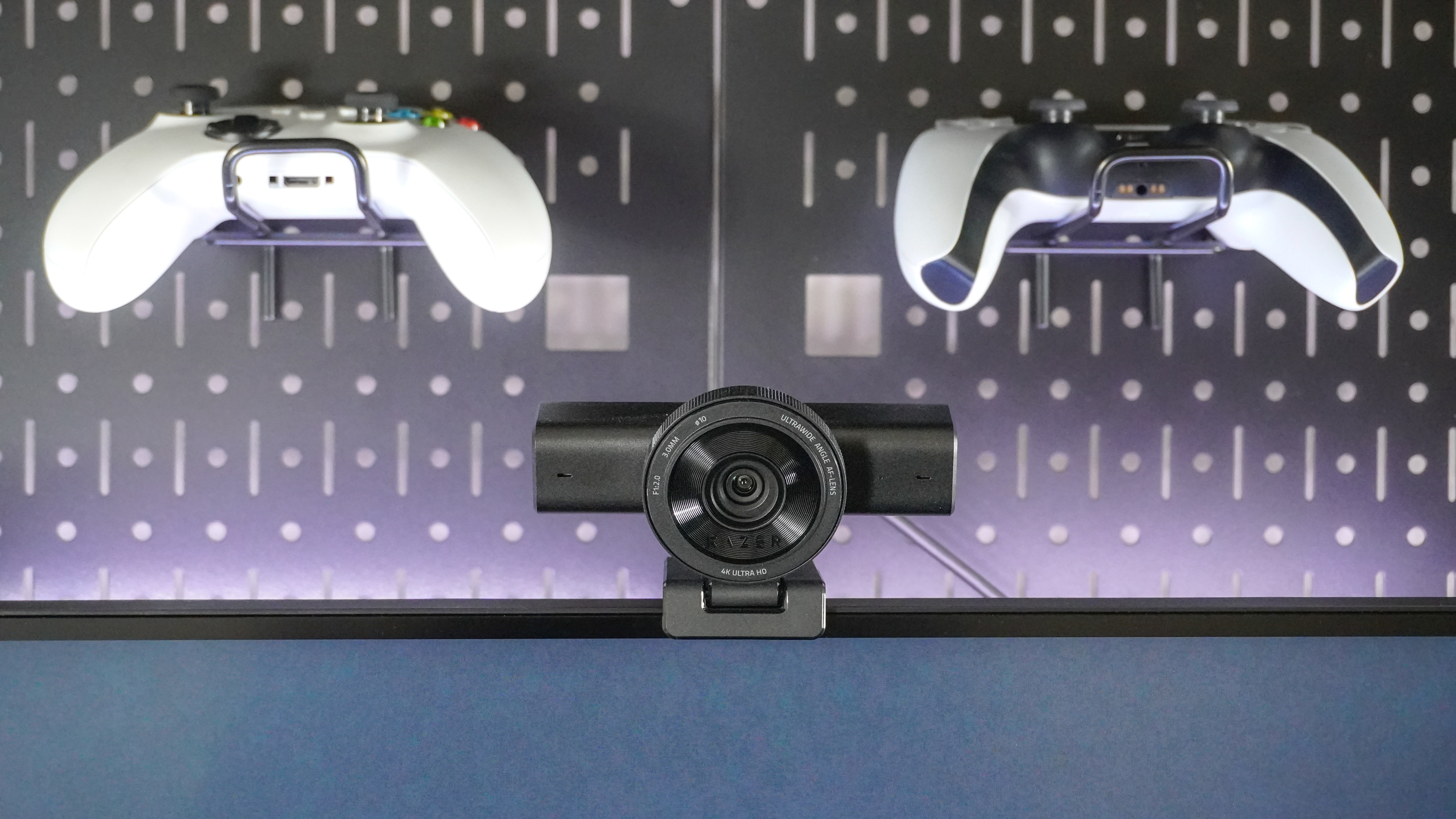 The Razer Kiyo V2 webcam on top of a monitor between two controllers