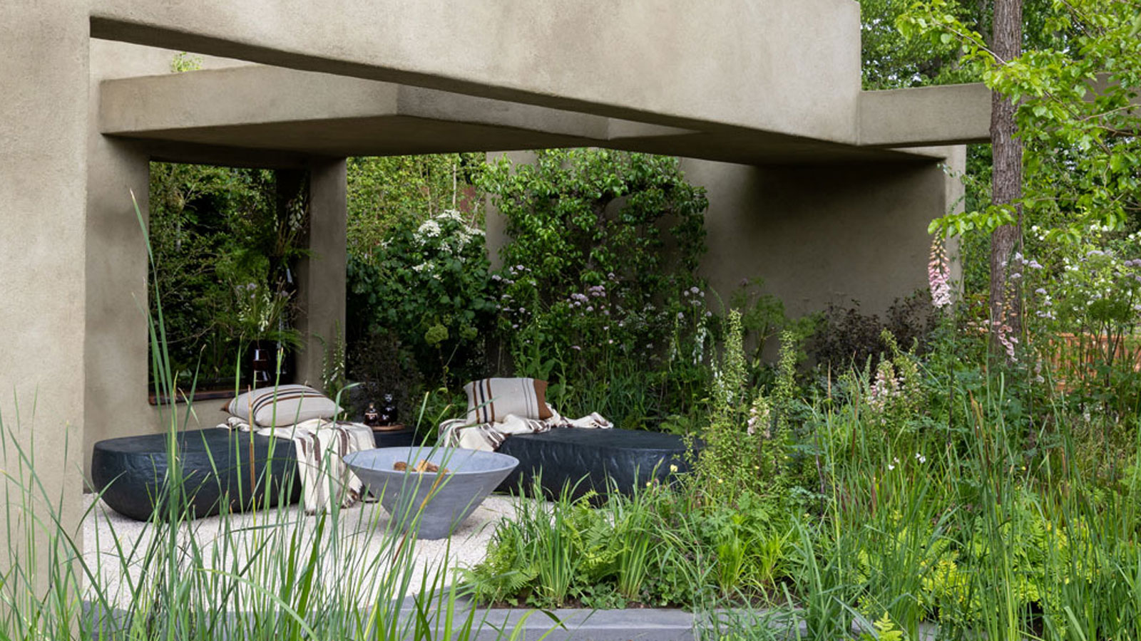 modern patio design with concrete pergola, garden furniture, firepit, and planting