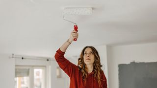 Woman preparing a ceiling ahead of painting