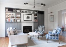 a living room with storage and blue patterned chairs