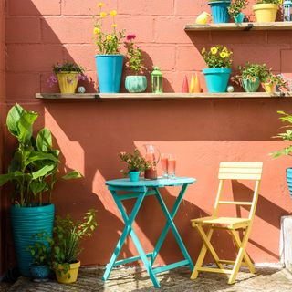 outdoor wall painted orange with shelves and planters