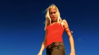 Mandy Moore in a red tank top singing "Candy" in the music video.