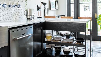 Monochrome open-plan kitchen diner with black cabinetry, patterned floor and peninsula with open storage