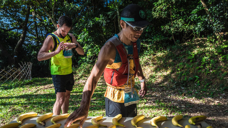 Chinese runner grabbing a banana at an aid station